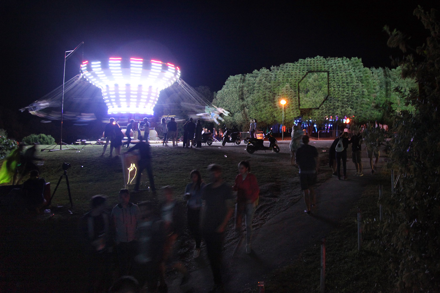 Geometrische Projektionen auf Bäume neben einem Fahrgeschäft – LIGHTHOUSE FESTIVAL, Lanterna, Tar, Kroatien