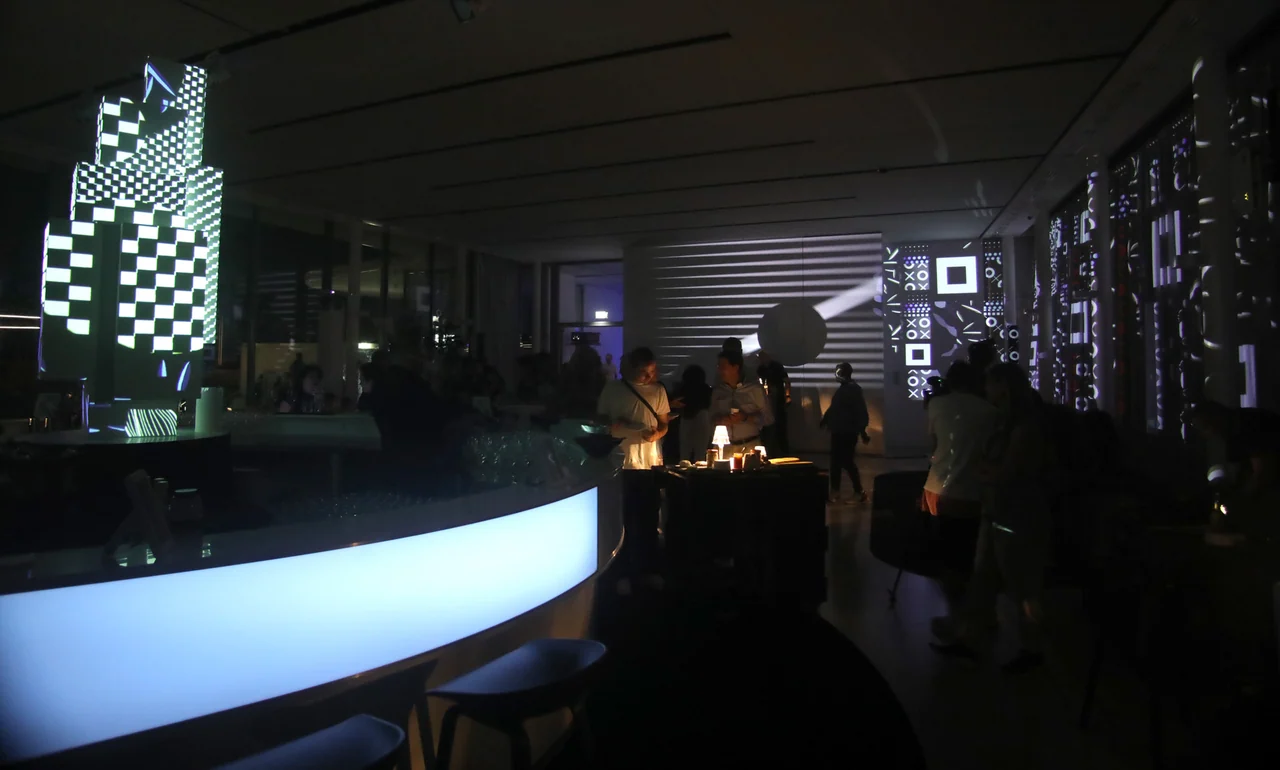 Schwarz-weiße Raumprojektionen hinter den Gästen – MQ LIBELLE, MQ Libelle, Wien, Österreich