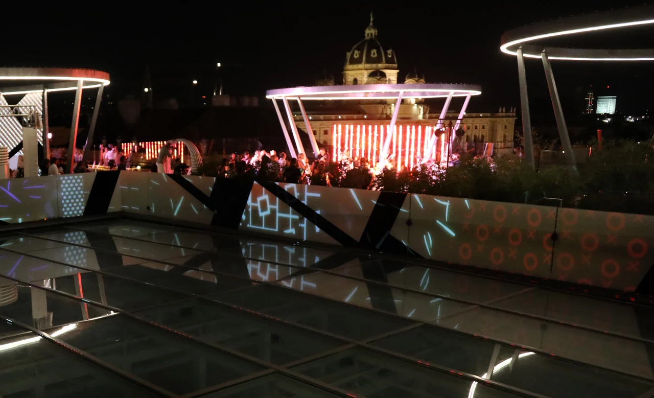 Weite Nachtansicht der Dachterrasse mit Projektionen – MQ LIBELLE, MQ Libelle, Wien, Österreich