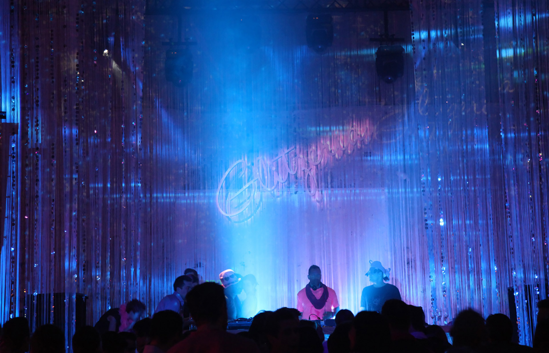 Bühne mit blauem Licht und Glitzeria-Projektion im Hintergrund – GLITZERIA, Ottakringer Brauerei, Wien, Österreich