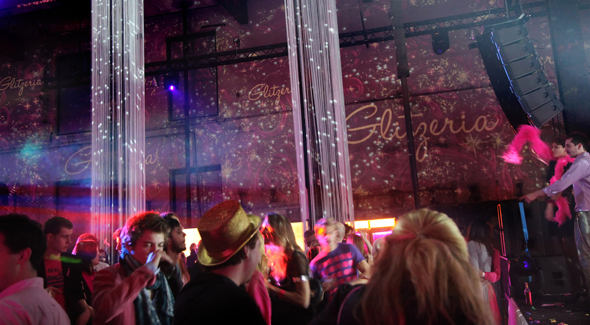 Gäste vor pinken Raumprojektionen und Glitzeria-Schriftzügen – GLITZERIA, Ottakringer Brauerei, Wien, Österreich