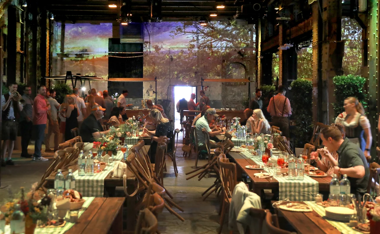 Gäste vor großflächigen Weinberg-Projektionen – IMS, Ottakringer Brauerei, Wien, Österreich