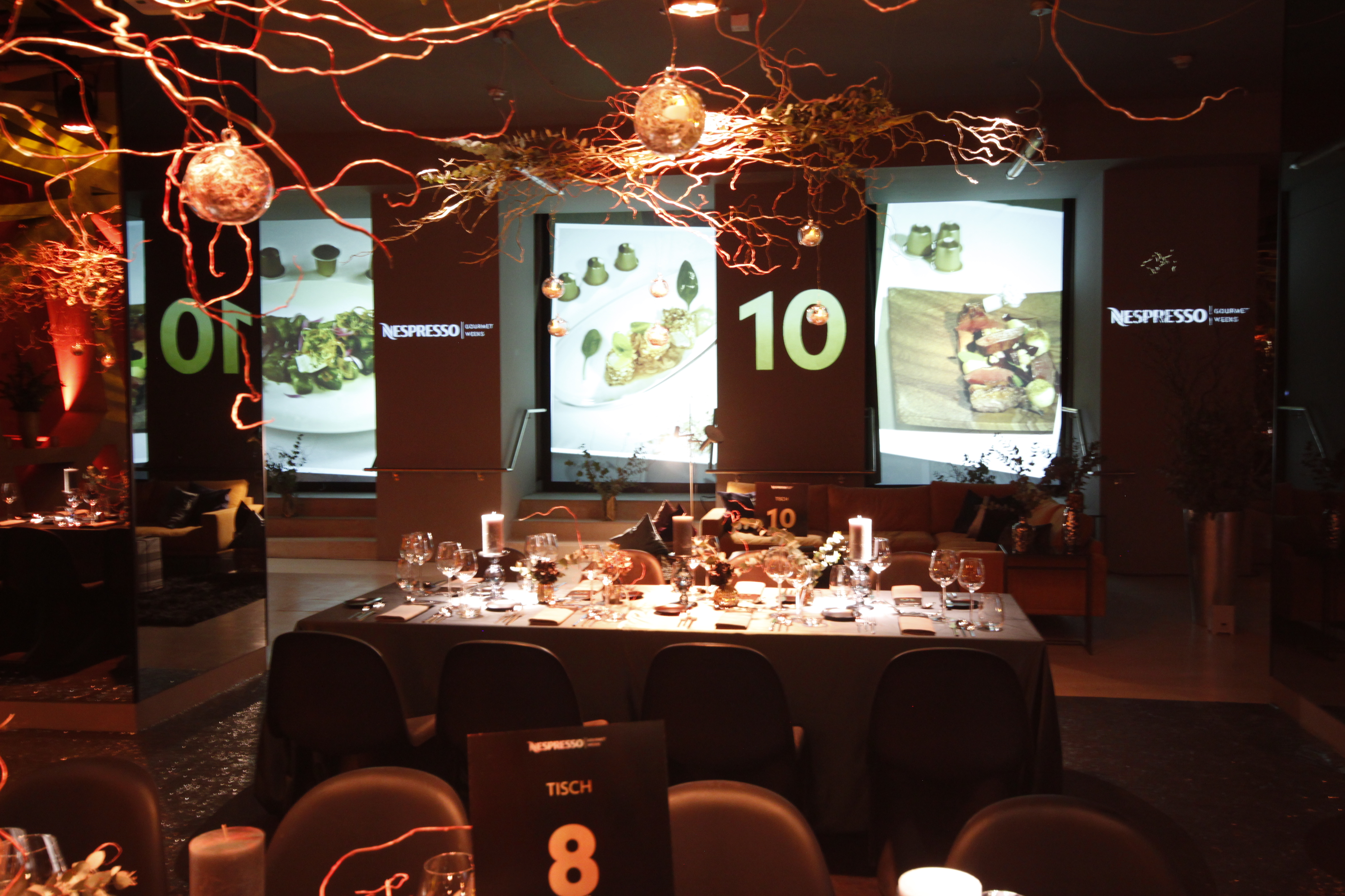 Dining tables beneath light installations in front of spatial projections – Nespresso, Palais Wertheim, Vienna, Austria