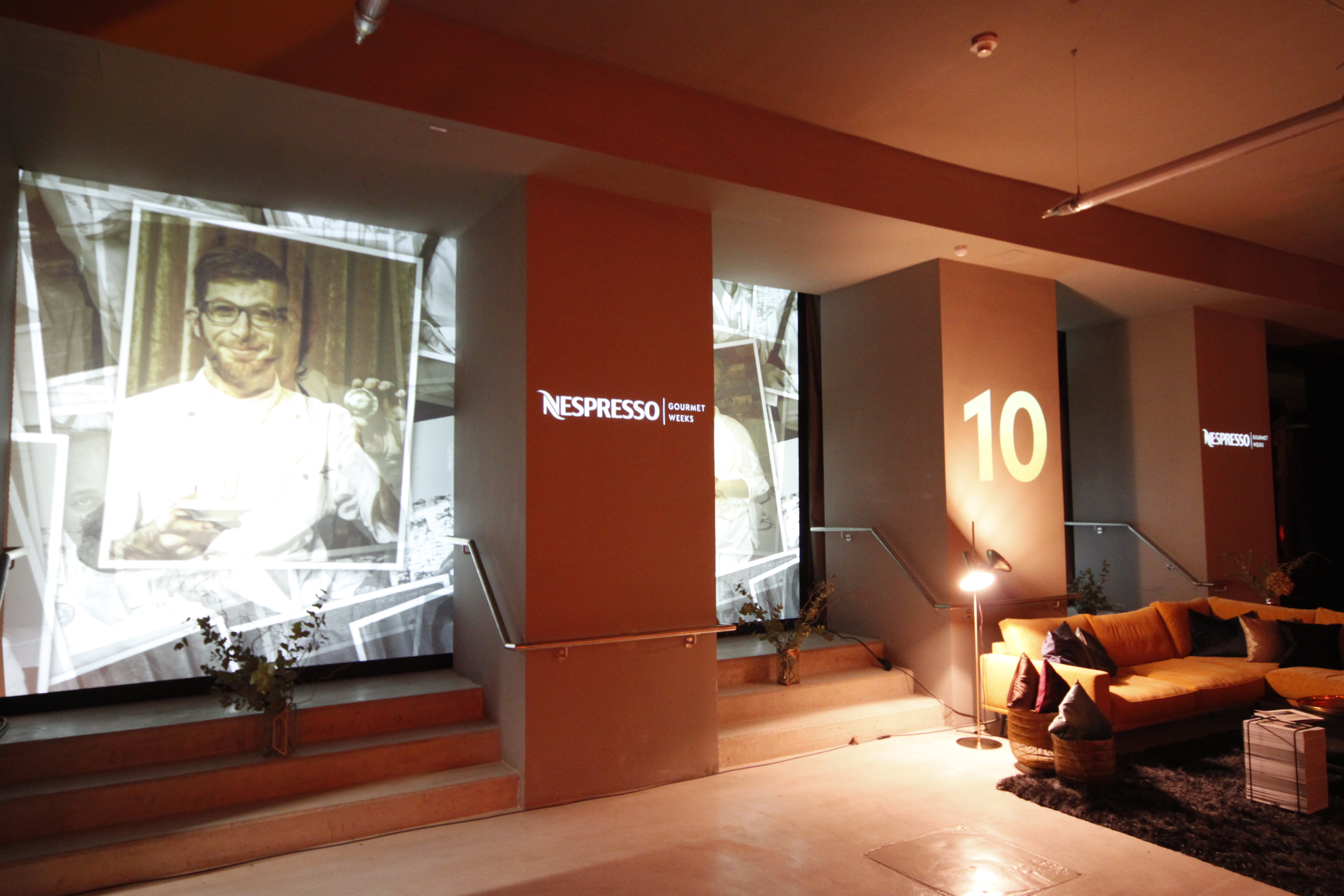 Portrait imagery projected onto a wall beside anniversary lettering – Nespresso, Palais Wertheim, Vienna, Austria