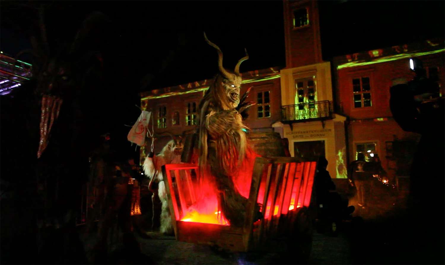 Krampusfigur vor der projizierten Rathausfassade und dem Publikum – Wachauer Advent, Videomapping in Spitz, Wachau, Österreich