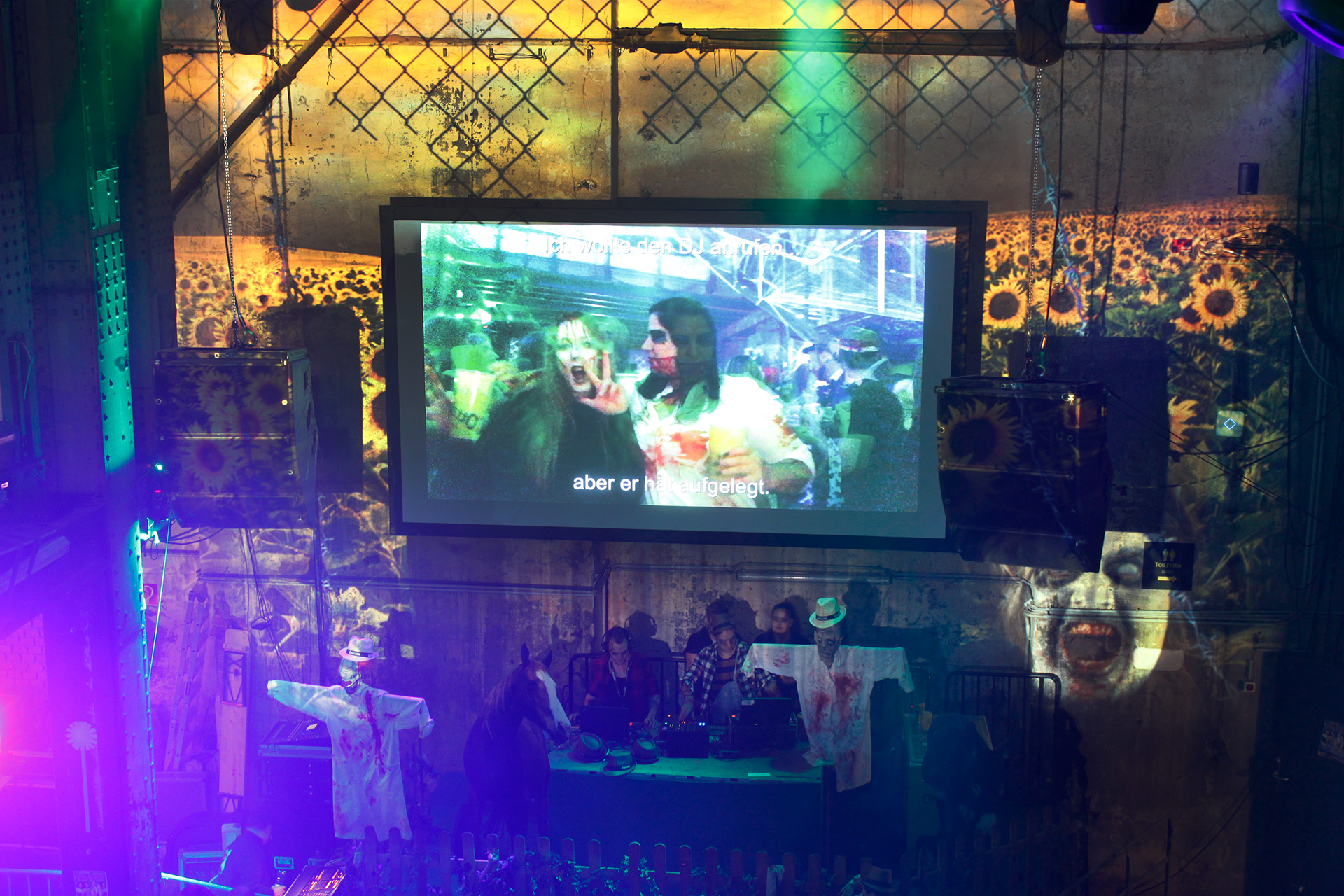 Gäste auf einem Monitor vor den großflächigen Projektionen – SCARY FEST, Ottakringer Brauerei, Wien, Österreich